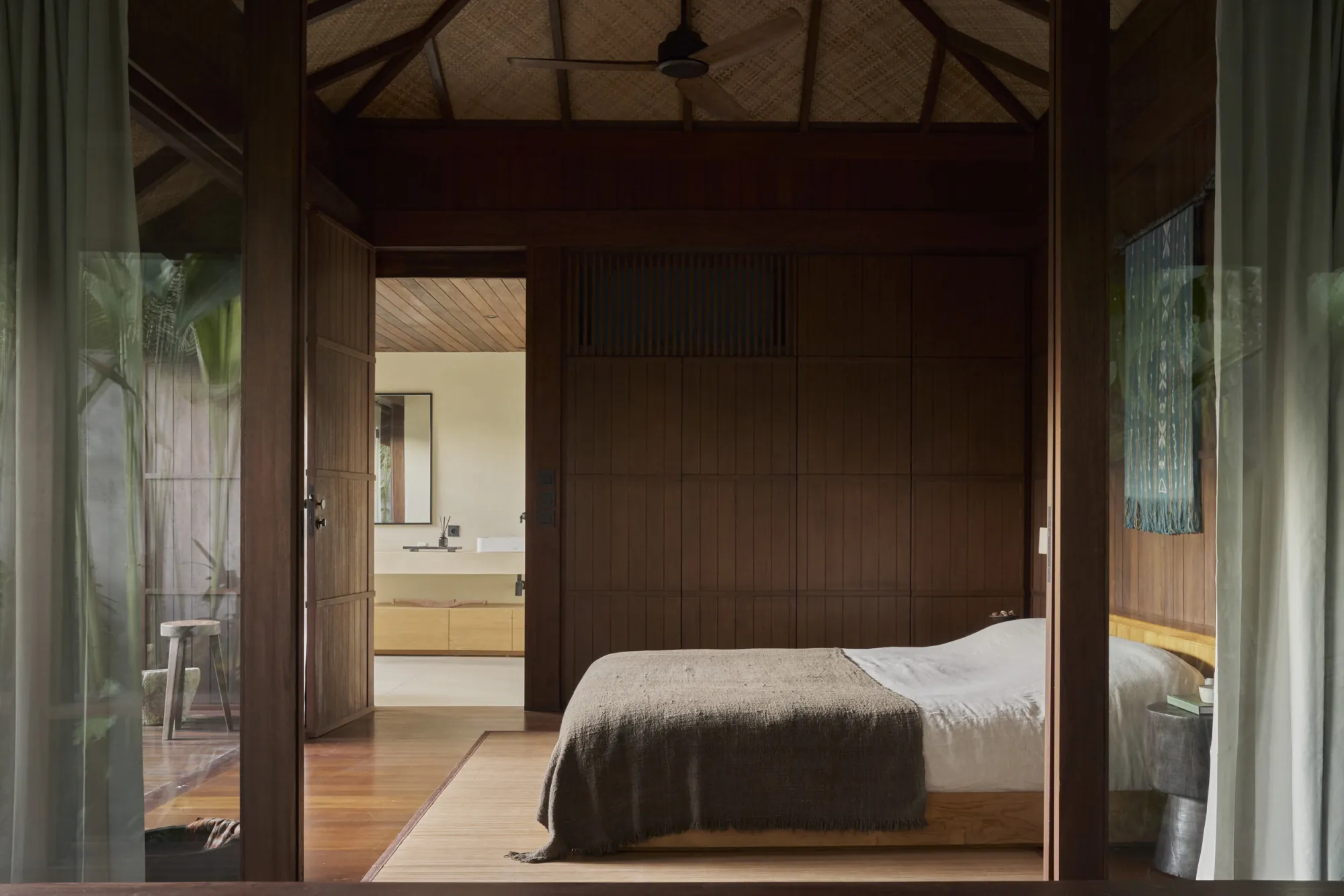 Bangkirai timber bedroom opening onto a shaded verandah at Rumah Haruku