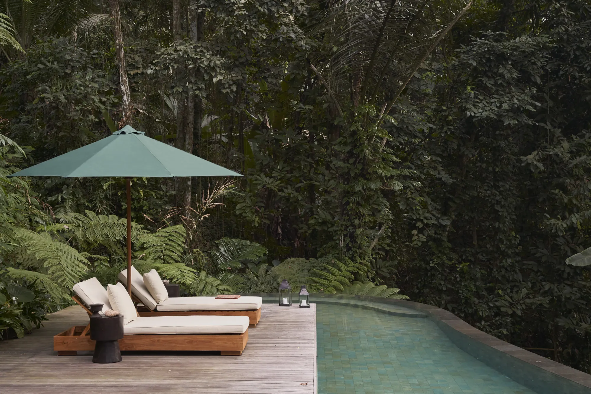 Swimming pool and timber deck within the tropical landscape at Rumah Haruku in Bali