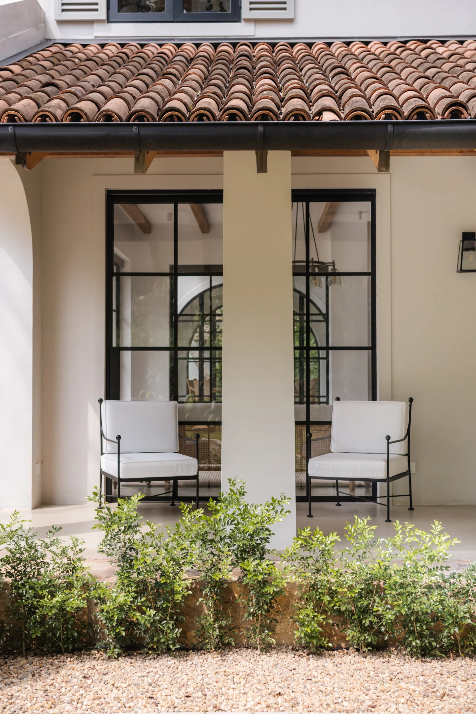 Sa House verandah with twin lounge chairs beneath a tiled roof