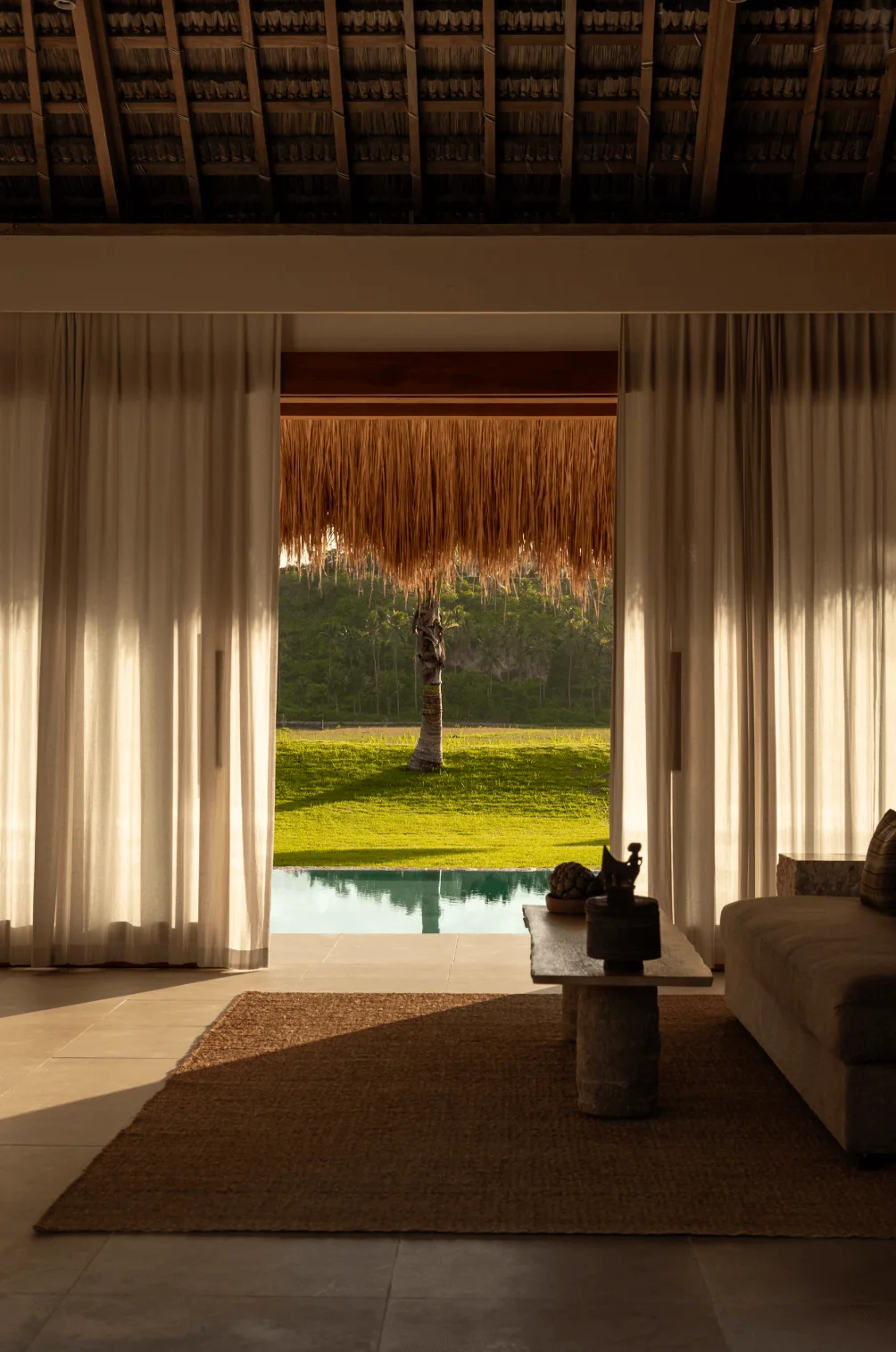 Garden villa living room opening to a private pool and lawn
