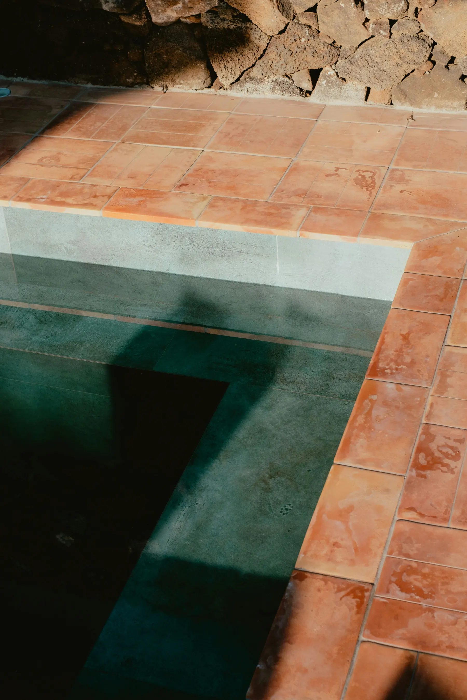 Terracotta floor tiles with earthy colour variation and handmade surface texture